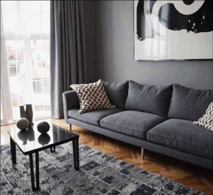 A sleek monochromatic living room featuring varying shades of gray with textured décor.