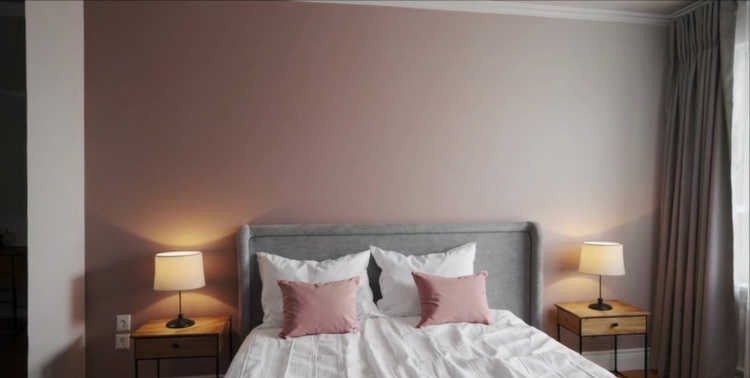 A soft ombré gradient wall blending blush pink and white in a cozy bedroom.