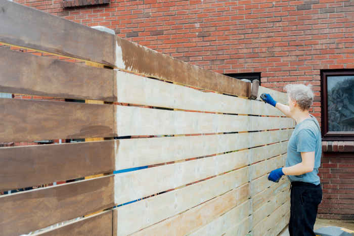 A wooden surface transitioning from painted to stained using a solid stain.