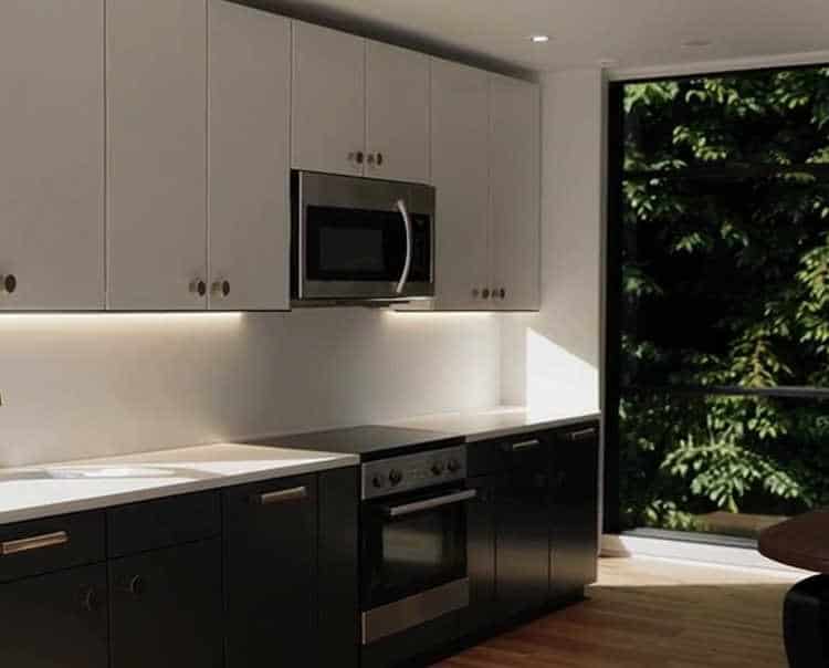 Matte black cabinet handles and brass door knobs in a modern kitchen.