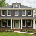 Cleveland colonial with deep espresso brown siding, white trim, and a sage green front door