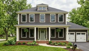 Cleveland colonial with deep espresso brown siding, white trim, and a sage green front door