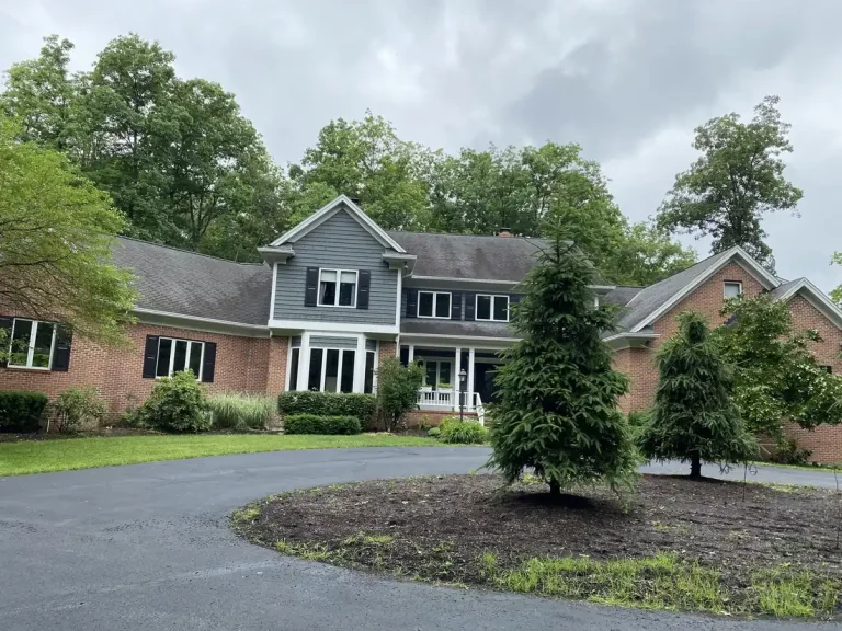 Brick and gray siding two-story home exterior after painting