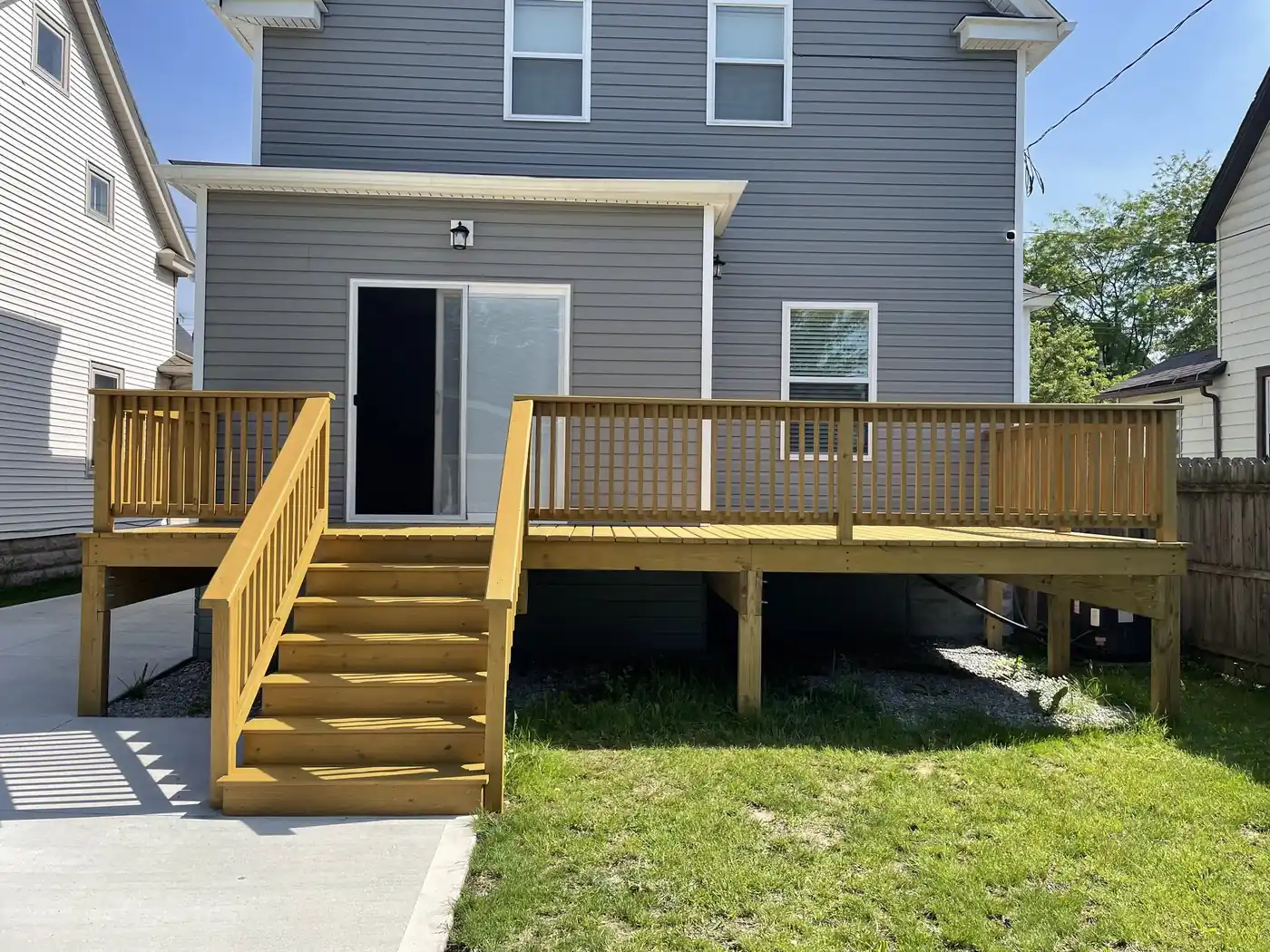 Gray two-story vinyl-sided home with a new wood deck, exterior painting by Crocker Home Painting in Westlake, Ohio