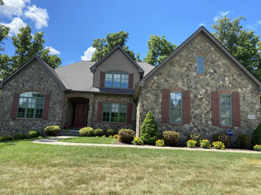 Two-story stone and gray siding home exterior after painting by Crocker Home Painting in Westlake, Ohio