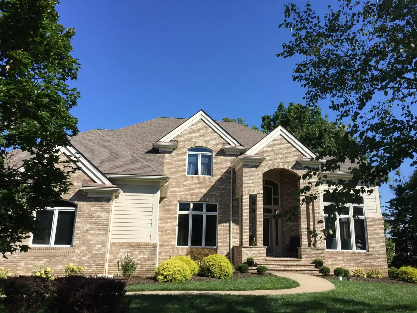 Stone and beige siding home exterior with covered entry after painting by Crocker Home Painting in Westlake, Ohio