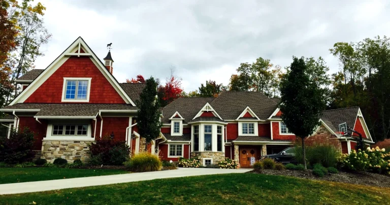 Red cedar shake home with stone base, white trim and dormers