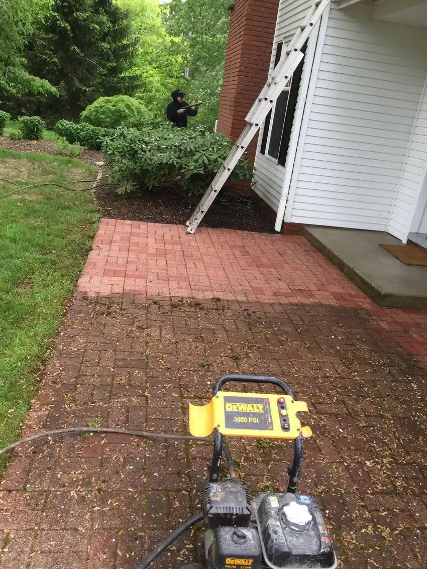 Power washing a brick patio and home siding before painting, by Crocker Home Painting in Westlake, Ohio